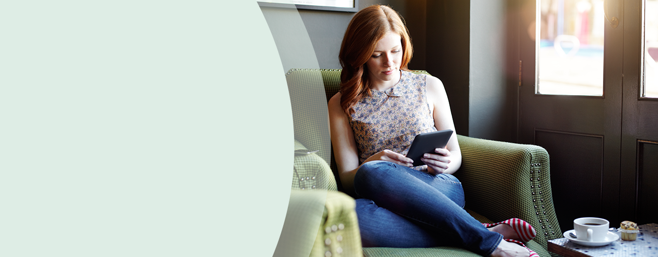 Rodina naprieč generáciami sedí na pohovke a spoločne si prezerá knihu.