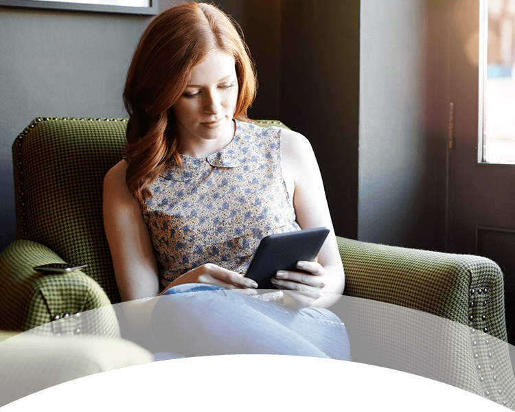 Rodina naprieč generáciami sedí na pohovke a spoločne si prezerá knihu.