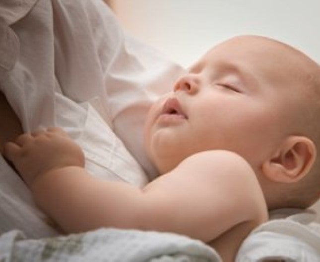 Dítě spí v náručí matky